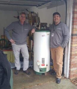 Two men standing with a waterheater